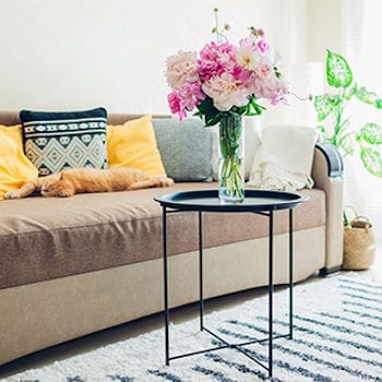 Pretty flowers on a table next to a comfortable couch