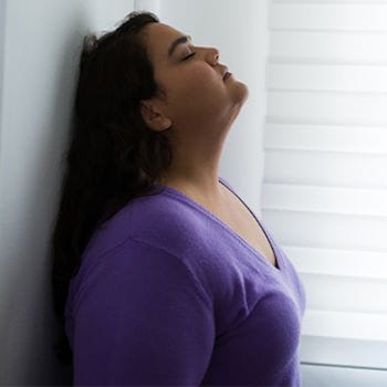 Jessie feeling stressed with her back against a wall